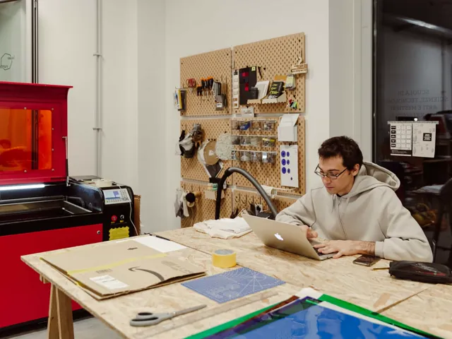 Tesista dell'Accademia di Costume e Moda alla postazione laser cutter