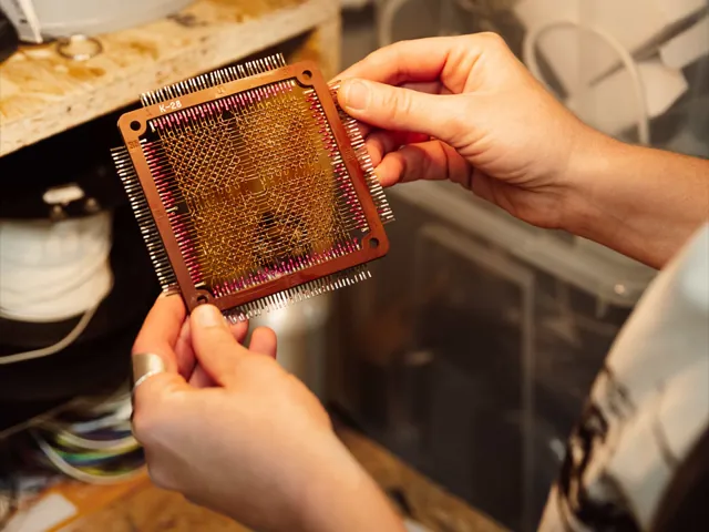 Mani che reggono una scheda di memoria a nuclei magnetici