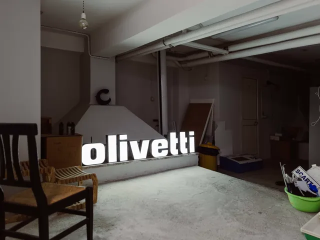 Insegna luminosa "olivetti" e lettera "c" nello Spazio Chirale