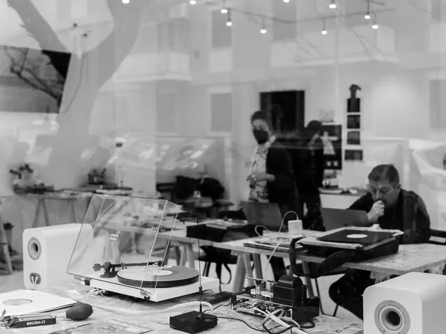 Giradischi vintage e bancone makerspace in attività, bianco e nero